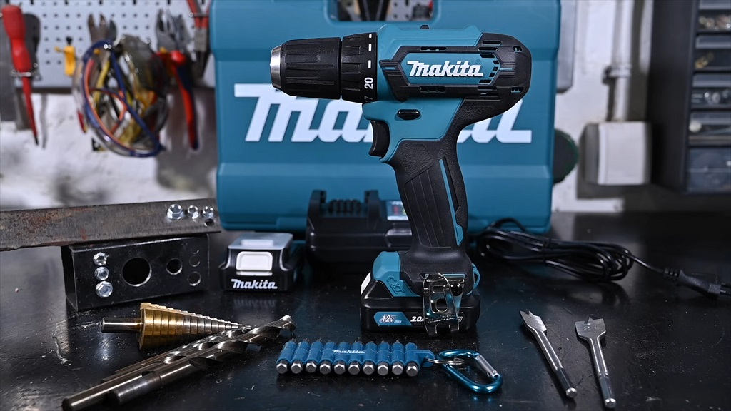 Makita akumulatorska bušilica sa priborom, burgijama i bitovima postavljenim na radnom stolu u radionici