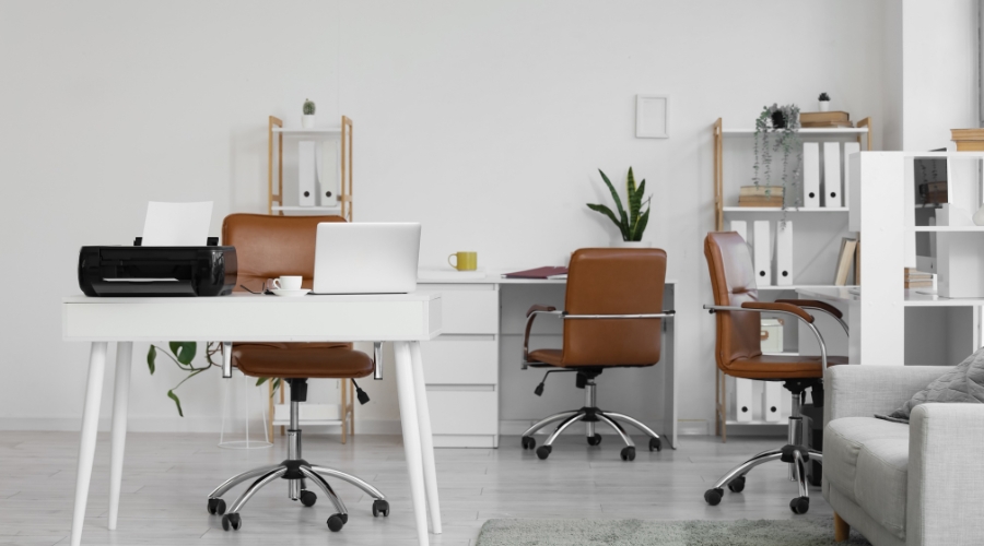 Moderna kancelarija sa belim stolovima, braon kancelarijskim stolicama, policama za odlaganje i sobnim biljkama.