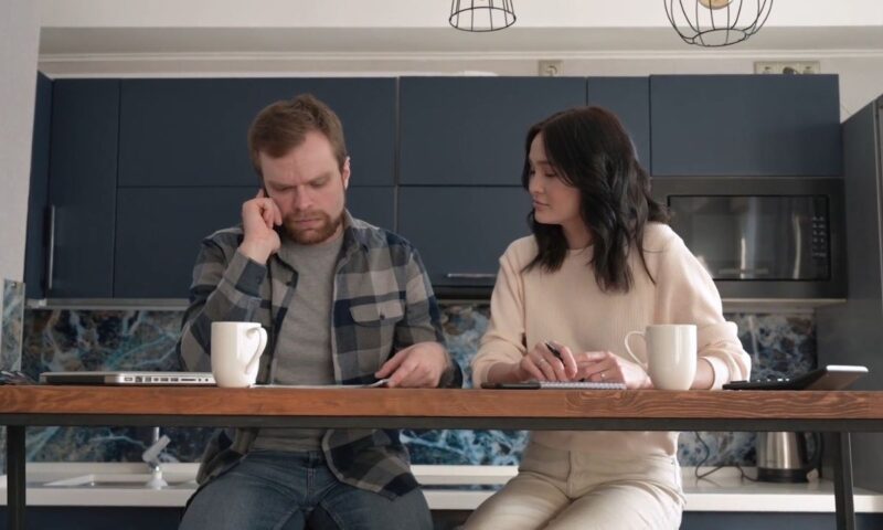 par gleda u papire, muška osoba priča preko telefona