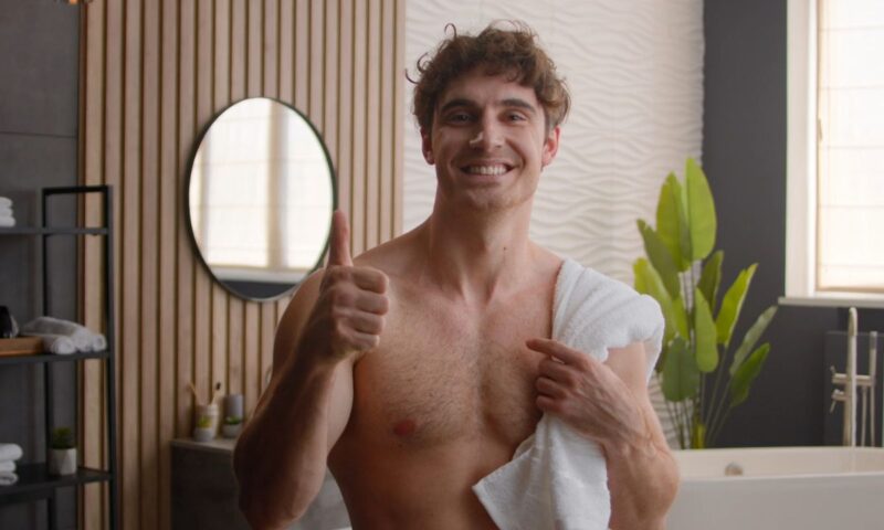 momak u kupatilu sa peškirom preko ramena podiže palac u obliku lajka 