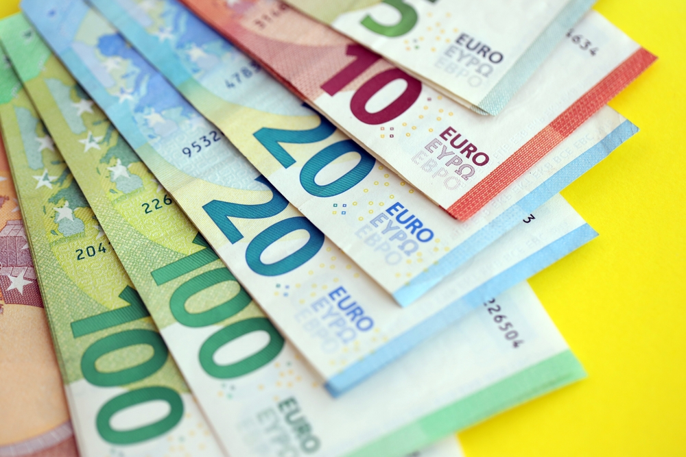 Novčanice evra različitih apoena raspoređene jedna preko druge na žutoj podlozi