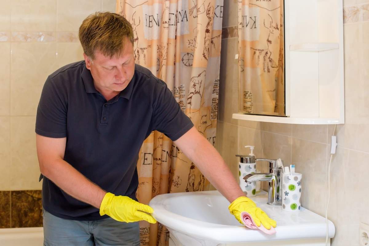muškarac detaljno čisti lavabo